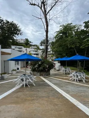 a group of tables and blue umbrellas in a parking lot at apartamento exclusivo con jacuzzi, piscina y vista al lago in Las Terrenas