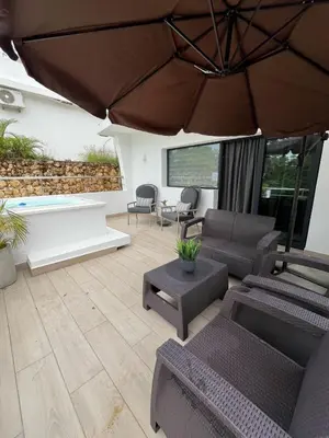 a living room with furniture and an umbrella at apartamento exclusivo con jacuzzi, piscina y vista al lago in Las Terrenas
