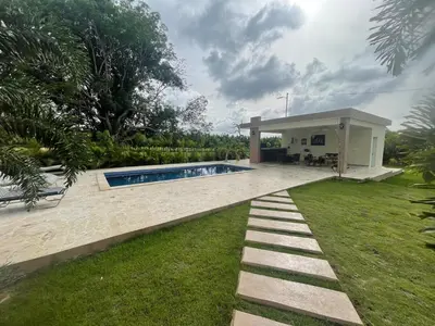 a backyard with a swimming pool and a house at Jeda Village in Higuey