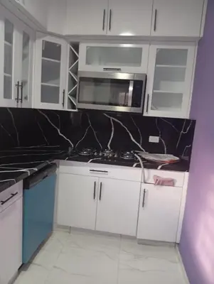 a kitchen with white cabinets and a microwave at Villa colombia in Miches