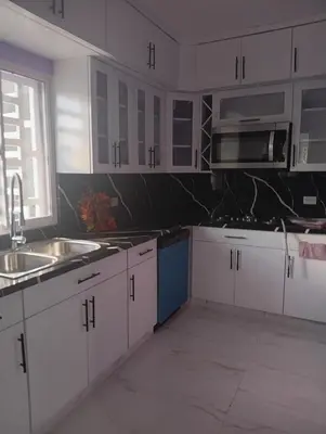 a kitchen with white cabinets and a sink and a microwave at Villa colombia in Miches