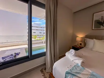 a bedroom with a window with a view of the ocean at Beautiful brand new Beach Condo w Picuzzi in Punta Cana