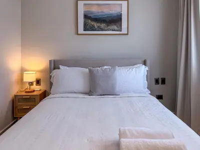 a bedroom with a large white bed with a night stand at Beautiful brand new Beach Condo w Picuzzi in Punta Cana