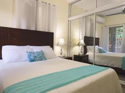 a bedroom with two beds and a large mirror at Majestic View Apartment II in San Felipe de Puerto Plata