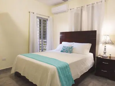 a bedroom with a bed with a blue pillow on it at Majestic View Apartment II in San Felipe de Puerto Plata