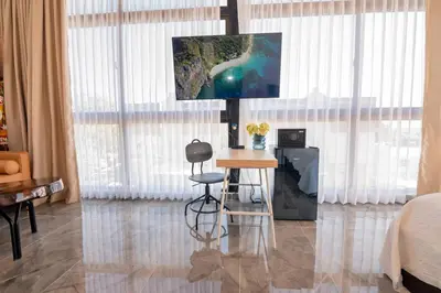 a living room with a table and a bed at Casa Ola & Surf in San Felipe de Puerto Plata