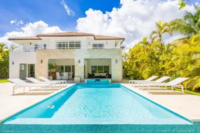 a villa with a swimming pool in front of a house at Buganvilla 252 Cocotal Villa - 4BR, Private Pool, Jacuzzi, Golf View in Punta Cana