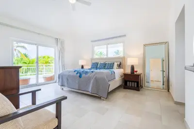 a bedroom with a bed and a large window at Buganvilla 252 Cocotal Villa - 4BR, Private Pool, Jacuzzi, Golf View in Punta Cana