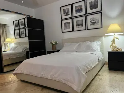 a bedroom with a large bed and pictures on the wall at Antiguo Dominican Bay in Cuevas