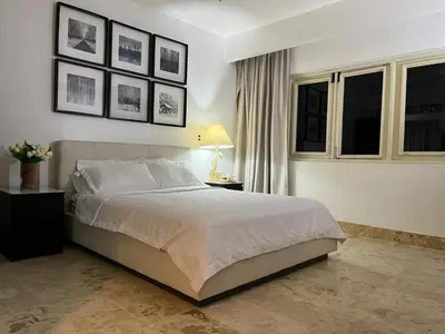a bedroom with a bed and pictures on the wall at Antiguo Dominican Bay in Cuevas