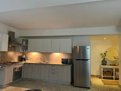 a kitchen with white cabinets and a stainless steel refrigerator at Antiguo Dominican Bay in Cuevas