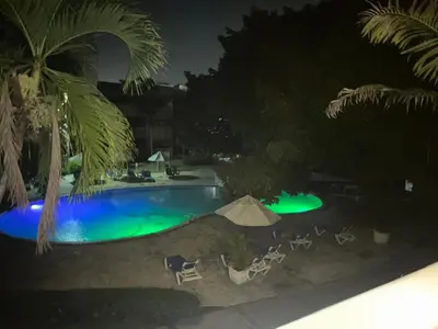 a pool at night with chairs and a tent at Antiguo Dominican Bay in Cuevas