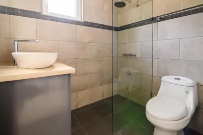 a bathroom with a toilet and a glass shower at Casa Mango- Relax - Pool Stunning Views in San Felipe de Puerto Plata