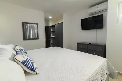 a bedroom with a bed and a tv on the wall at Casa Mango- Relax - Pool Stunning Views in San Felipe de Puerto Plata