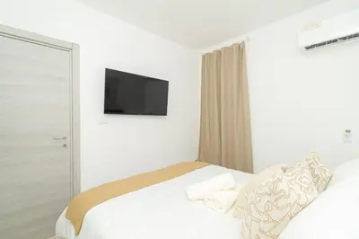 a bedroom with a bed with a television on the wall at Coastal Comfort in Bayahibe 2BR 2BA Carribean Rose in San Rafael del Yuma
