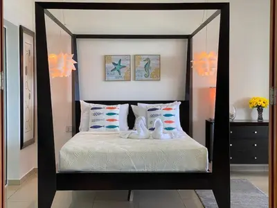 a bedroom with a black and white canopy bed at Cozy Beach Front Condo, Pool in La Puntica de Juan Dolio