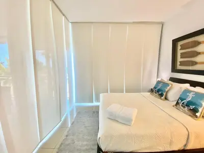 a small bedroom with a bed and a window at Cozy Beach Front Condo, Pool in La Puntica de Juan Dolio
