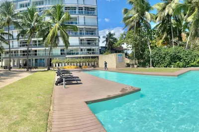 a swimming pool in front of a tall building at Cozy Beach Front Condo, Pool in La Puntica de Juan Dolio