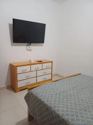 a bedroom with a dresser with a flat screen tv at Sunset Apartment Beach Residences Steps from the Beach in Puerto Plata