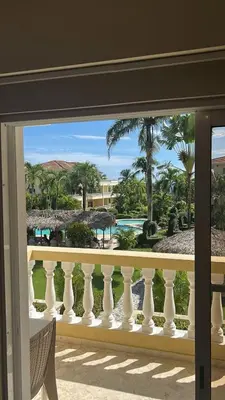 a balcony with a view of the ocean and palm trees at Marvilla - Coastal Condo Poolside & Ocean View in Boca Chica
