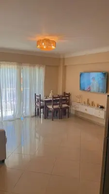 a living room with a table and a tv on the wall at Marvilla - Coastal Condo Poolside & Ocean View in Boca Chica
