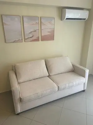 a couch in a room with three pictures on the wall at Marvilla - Coastal Condo Poolside & Ocean View in Boca Chica