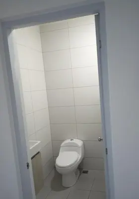a white bathroom with a toilet and a sink at Sunrise Apartments in San Felipe de Puerto Plata