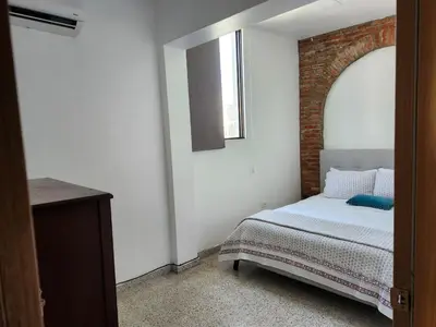 a bedroom with a bed and a brick wall at Apartment in Zona Colonial in Santo Domingo