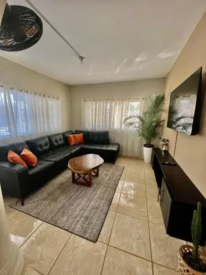 a living room with a black couch and a table at Cheerfull 4 bedroom Villa with pool #VillaLioness in Nagua