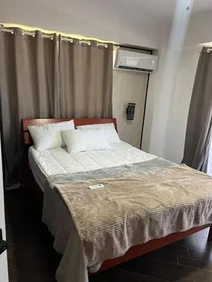 a bedroom with a large bed with white sheets and pillows at Brisa de Mar in Boca Chica