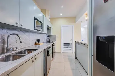 a large kitchen with a sink and a dishwasher at Apartamento Hermoso Frente Al Mar 11fl Amanzing in Juan Dolio