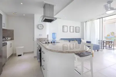 a kitchen and living room with a counter and a table at Apartamento En Marbella Vista Al Mar in Villas del Mar
