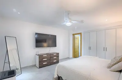 a bedroom with a bed and a television on the wall at Apartamento En Marbella Vista Al Mar in Villas del Mar