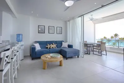 a living room with a blue couch and a table at Apartamento En Marbella Vista Al Mar in Villas del Mar