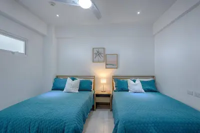 two beds in a room with blue sheets at Apartamento En Marbella Vista Al Mar in Villas del Mar