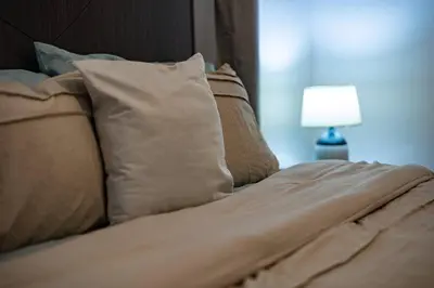 a bed with pillows and a nightstand with a lamp at Coralclifftower in Juan Dolio