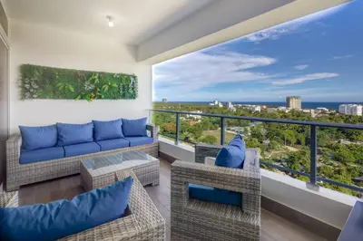 a living room with a couch and chairs on a balcony at Coralclifftower in Juan Dolio