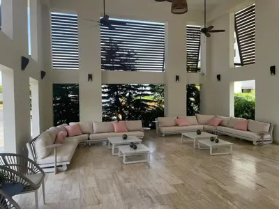 a living room with couches and tables and windows at Coralclifftower in Juan Dolio