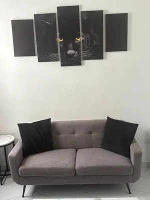a couch in a living room with paintings of a black cat at LEVEL suites in Sosúa