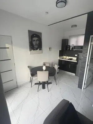 a living room with a table and chairs and a kitchen at LEVEL suites in Sosúa