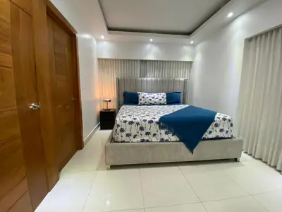 a bedroom with a bed with a blue comforter at Maravilloso Descanso in Santo Domingo