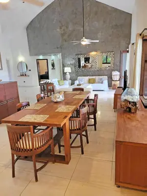 a dining room with a large wooden table and chairs at Villa Bali in Paraíso