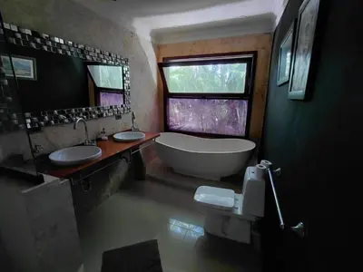 a bathroom with two sinks and a tub and a window at Villa Bali in Paraíso