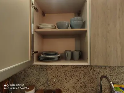 a cupboard with plates and bowls in it at Relax in Style at Hard Rock Hotel Punta Cana Apartment in Punta Cana