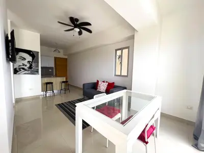 a living room with a blue couch and a ceiling fan at Apartamento en Boca Chica T2 707 in Boca Chica