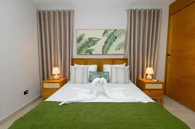 a bedroom with a large bed with a green blanket at Tropical 1BR Getaway in Dominicus Bayahibe - Garden Breeze