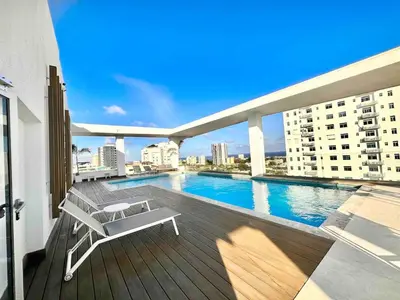 a balcony with a swimming pool on a building at Comfy Apt, Rooftop Lounge, Pool in Santo Domingo