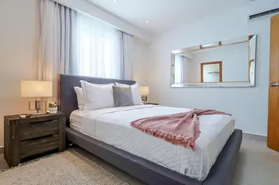 a bedroom with a large bed and a mirror at Comfy 1BR Apt, Centric Full AC in Santo Domingo