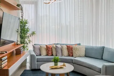 a living room with a blue couch and a table at Comfy 1BR Apt, Centric Full AC in Santo Domingo