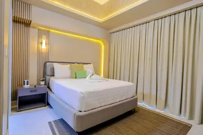 a bedroom with a white bed with a yellow ceiling at Luxury Upscale Centric Condo, in Santo Domingo